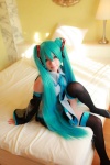 aqua_hair arai_yomi bed blouse cosplay detached_sleeves hatsune_miku headset pleated_skirt skirt thighhighs tie twintails vocaloid zettai_ryouiki rating:Safe score:1 user:nil!