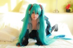 aqua_hair arai_yomi bed blouse cleavage cosplay detached_sleeves hatsune_miku headset open_clothes pleated_skirt skirt thighhighs tie twintails vocaloid rating:Safe score:1 user:nil!