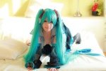 aqua_hair arai_yomi bed blouse cleavage cosplay detached_sleeves hatsune_miku headset open_clothes pleated_skirt skirt thighhighs tie twintails vocaloid rating:Safe score:1 user:nil!