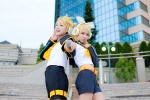 blonde_hair blouse blue_eyes cosplay crossplay detached_sleeves hairbow hair_clips headset kagamine_len kagamine_rin mogeta scarf_tie shorts uri vocaloid rating:Safe score:0 user:pixymisa