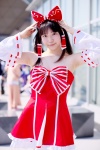 androp bow cosplay detached_sleeves dress hairbow hakurei_reimu quad_tails touhou rating:Safe score:0 user:pixymisa