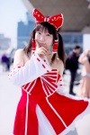 androp bow cosplay detached_sleeves dress hairbow hakurei_reimu quad_tails skirt skirt_lift touhou rating:Safe score:0 user:pixymisa